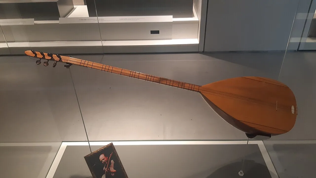 A saz displayed as Neşet Ertaş's instrument at the AKM Music Platform, photographed in 2022.