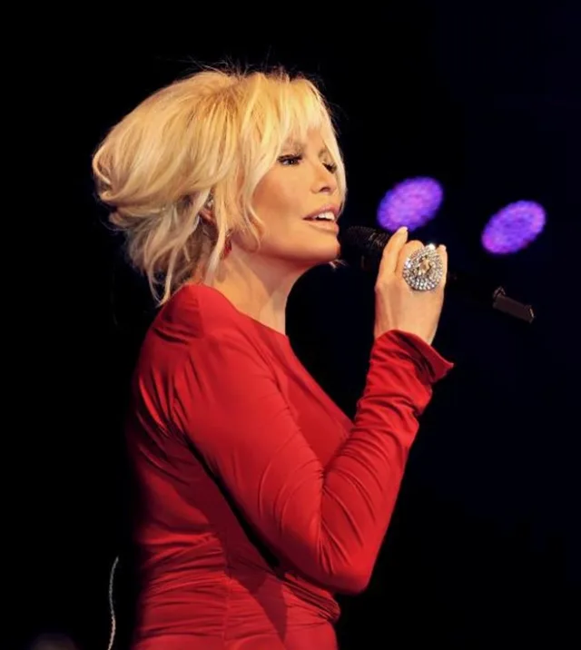 Ajda Pekkan holding a microphone in a red stage outfit, photographed on 9 May 2013