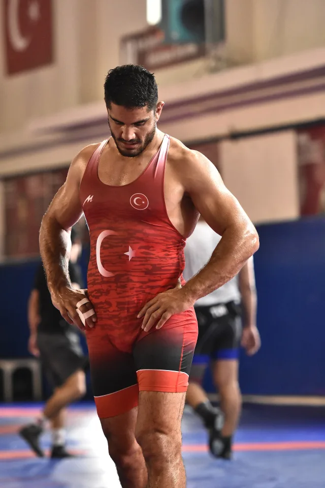 Taha Akgül wearing a red national-team singlet in a training hall