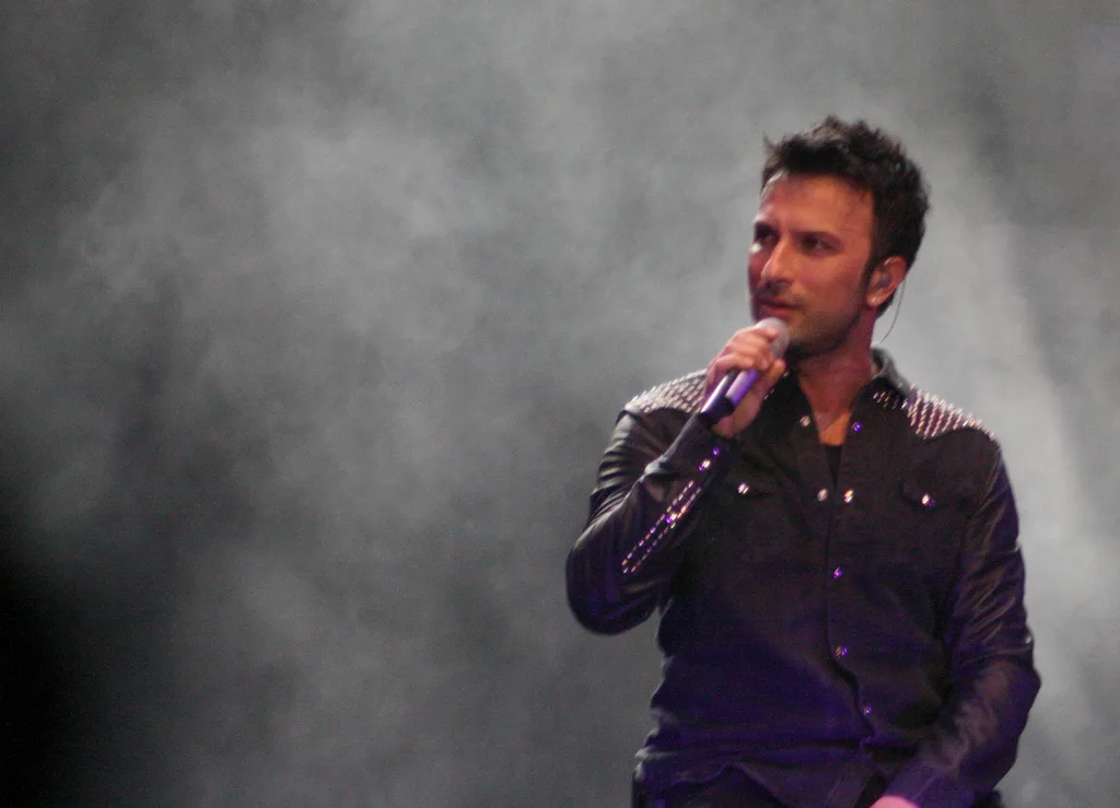 Tarkan holding a microphone onstage in a concert photograph dated 24 April 2011