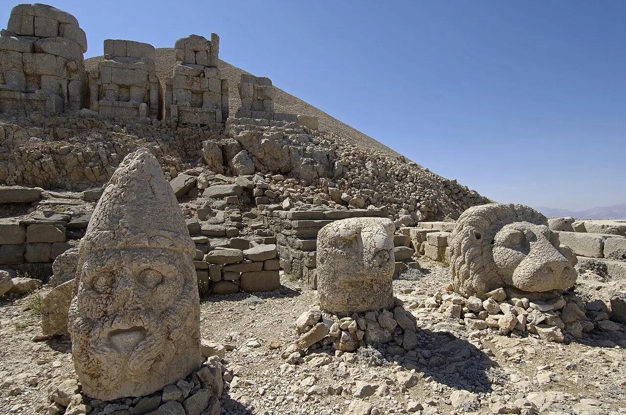 Sculptural heads, an eagle and a lion before stone statue bodies on Nemrut's east terrace