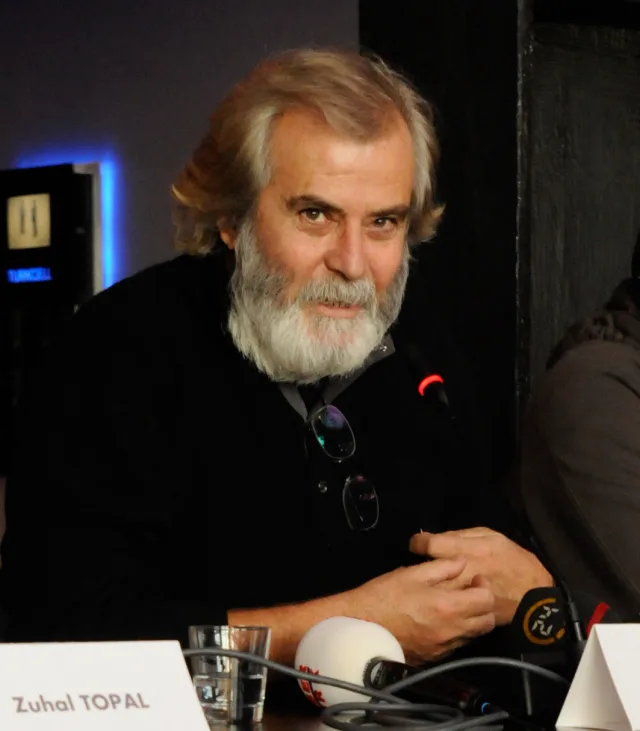Tarık Akan at the Deli Deli Olma press conference, pictured behind microphones in 2008